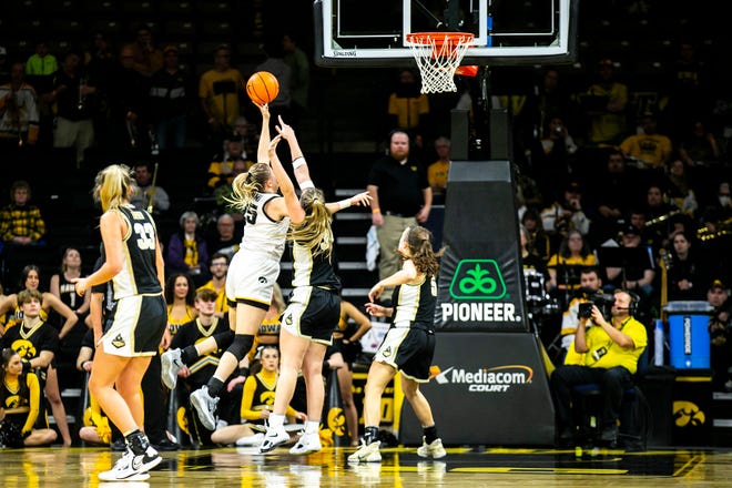 Iowa center Monika Czinano, second from left, shoots the ball as Purdue forward Caitlin Harper and guard Cassidy Hardin (5) defend during a NCAA Big Ten Conference women's basketball game, Thursday, Dec. 29, 2022, at Carver-Hawkeye Arena in Iowa City, Iowa.