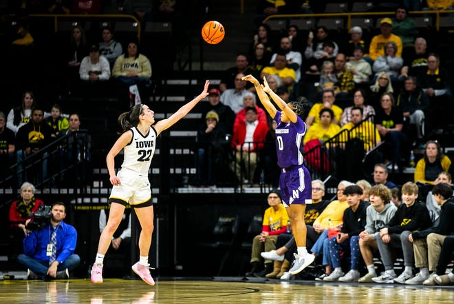 Northwestern guard Kaylah Rainey, right, shoots a 3-point basket as Iowa guard Caitlin Clark defends during a NCAA Big Ten Conference women's basketball game, Wednesday, Jan. 11, 2023, at Carver-Hawkeye Arena in Iowa City, Iowa.