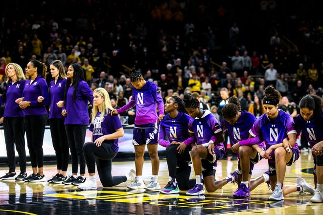 Northwestern Wildcats players kneel as the national anthem is performed before a NCAA Big Ten Conference women's basketball game against Iowa, Wednesday, Jan. 11, 2023, at Carver-Hawkeye Arena in Iowa City, Iowa.