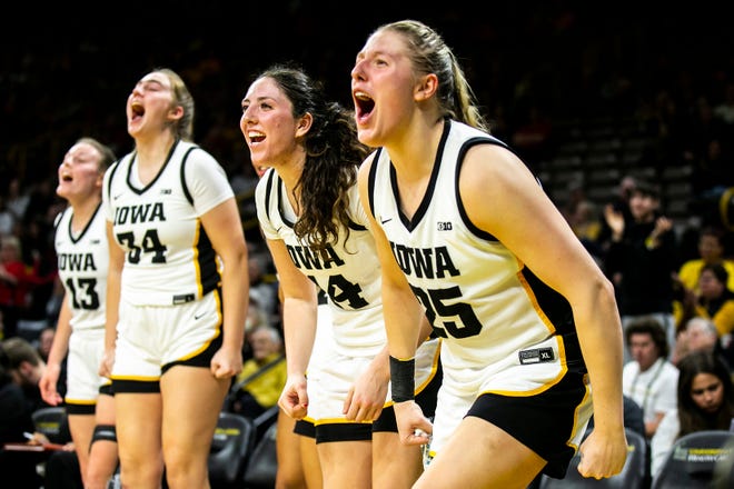 Iowa's McKenna Warnock, second from right, and Monika Czinano (25) cheer on teammates during a NCAA Big Ten Conference women's basketball game against Northwestern, Wednesday, Jan. 11, 2023, at Carver-Hawkeye Arena in Iowa City, Iowa.