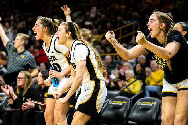 Iowa Hawkeyes players, from left, Kate Martin, Molly Davis, and AJ Ediger cheer on teammates during a NCAA Big Ten Conference women's basketball game against Northwestern, Wednesday, Jan. 11, 2023, at Carver-Hawkeye Arena in Iowa City, Iowa.