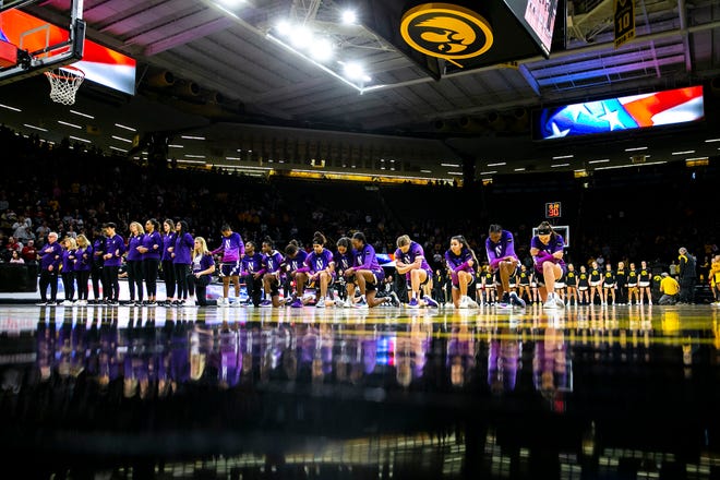 Northwestern Wildcats players kneel as the national anthem is performed before a NCAA Big Ten Conference women's basketball game against Iowa, Wednesday, Jan. 11, 2023, at Carver-Hawkeye Arena in Iowa City, Iowa.