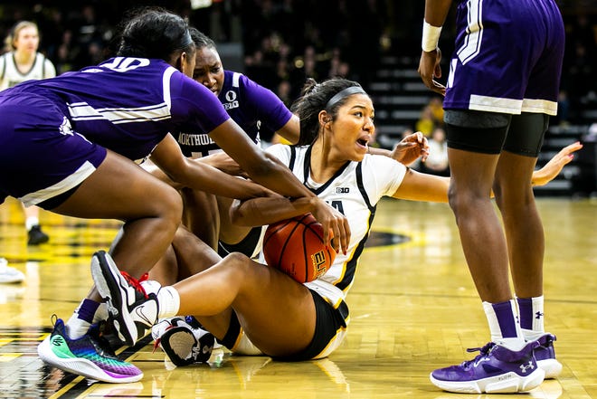 Iowa forward Jada Gyamfi, right, looks to the bench to call a timeout while fighting for a loose ball during a NCAA Big Ten Conference women's basketball game against Northwestern, Wednesday, Jan. 11, 2023, at Carver-Hawkeye Arena in Iowa City, Iowa.