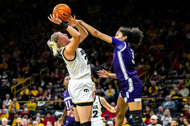 Iowa center Monika Czinano, left, gets fouled by Northwestern's Sydney Wood during a NCAA Big Ten Conference women's basketball game, Wednesday, Jan. 11, 2023, at Carver-Hawkeye Arena in Iowa City, Iowa.