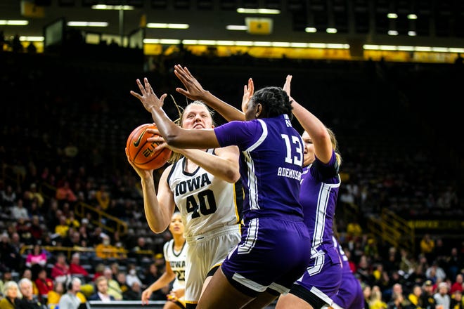 Iowa center Sharon Goodman, left, shoots the ball as Northwestern forward Mercy Ademusayo (13) defends during a NCAA Big Ten Conference women's basketball game, Wednesday, Jan. 11, 2023, at Carver-Hawkeye Arena in Iowa City, Iowa.