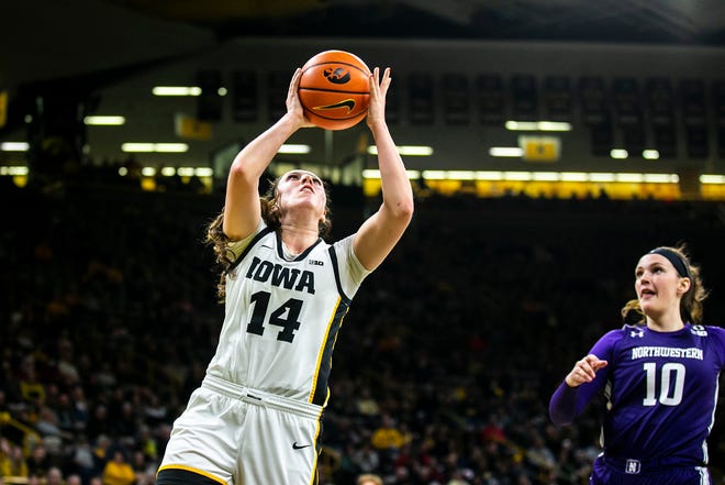 Iowa's McKenna Warnock, left, shoots a basket as Northwestern forward Caileigh Walsh defends during a NCAA Big Ten Conference women's basketball game, Wednesday, Jan. 11, 2023, at Carver-Hawkeye Arena in Iowa City, Iowa.