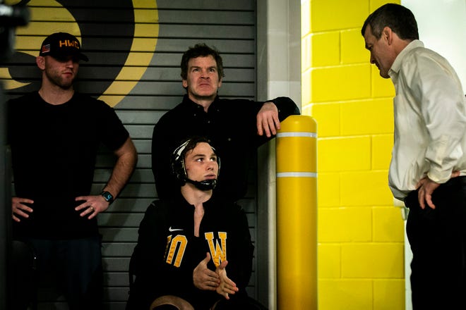 Iowa's Spencer Lee, seated, talks with Iowa head coach Tom Brands, right, as Alex Marinelli and associate head coach Terry Brands look on as he gets ready before wrestling at 125 pounds during a NCAA Big Ten Conference men's wrestling dual against Northwestern, Friday, Jan. 13, 2023, at Carver-Hawkeye Arena in Iowa City, Iowa.