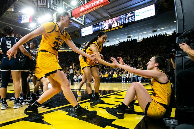 Iowa guard Caitlin Clark, right, gets helped up by teammates Kate Martin, left, and Hannah Stuelke during a NCAA Big Ten Conference women's basketball game against Penn State, Saturday, Jan. 14, 2023, at Carver-Hawkeye Arena in Iowa City, Iowa.