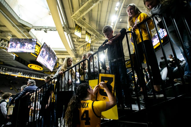 Iowa's McKenna Warnock (14) signs an autograph for a fan after a NCAA Big Ten Conference women's basketball game against Penn State, Saturday, Jan. 14, 2023, at Carver-Hawkeye Arena in Iowa City, Iowa. Iowa won 108-67.