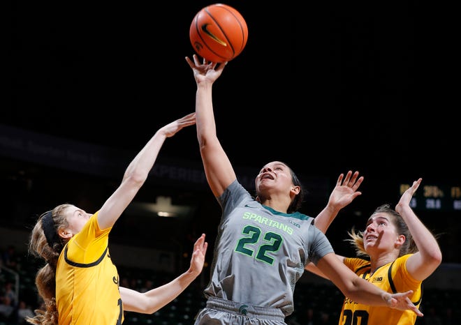 Michigan State's Moira Joiner, center, shoots between Iowa's Molly Davis, left, and Kate Martin, Wednesday, Jan. 18, 2023, in East Lansing.