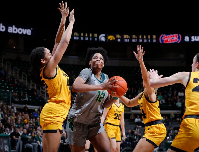 Michigan State's Isaline Alexander, center, maneuvers for a shot against Iowa's Hannah Stuelke, left, and Gabbie Marshall Wednesday, Jan. 18, 2023, in East Lansing.