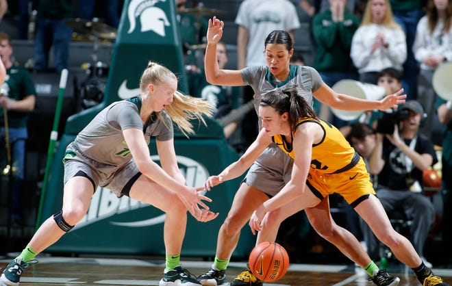 Iowa's Caitlin Clark, right, and Michigan State's Matilda Ekh, left, and Moira Joiner vie for a loose ball, Wednesday, Jan. 18, 2023, in East Lansing.