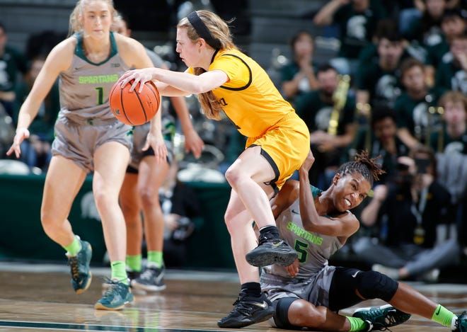 Michigan State ' s Kamaria McDaniel, right, and Iowa ' s Molly Davis get tangled up, Wednesday, Jan. 18, 2023, in East Lansing.