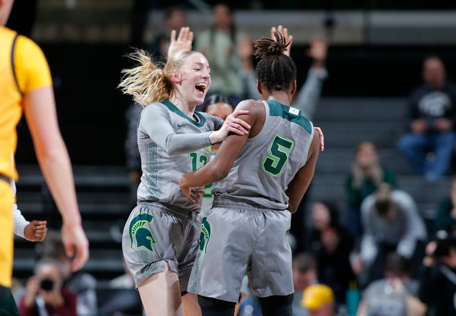 Michigan State's Kamaria McDaniel, right, and Stephanie Visscher celebrate McDaniel's half-court buzzer beater in the second quarter against Iowa, Wednesday, Jan. 18, 2023, in East Lansing.