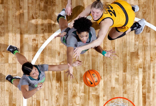 Michigan State's Isaline Alexander, center, and Moira Joiner, left, and Iowa's Monika Czinano, right, vie for a rebound, Wednesday, Jan. 18, 2023, in East Lansing.
