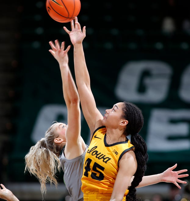 Michigan State's Tory Ozment, left, and Iowa's Hannah Stuelke tip off at the start of overtime, Wednesday, Jan. 18, 2023, in East Lansing.