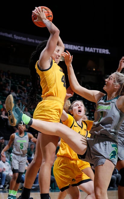 Michigan State's Tory Ozment, right, and Iowa's Hannah Stuelke, left, and Molly Davis battle for a rebound, Wednesday, Jan. 18, 2023, in East Lansing.