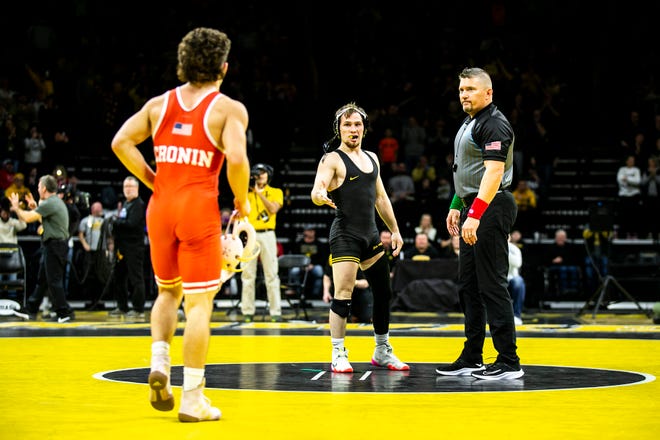 Iowa's Spencer Lee, center, reaches out to shake the hand of Nebraska's Liam Cronin after pinning him at 125 pounds during a Big Ten Conference men's wrestling dual, Friday, Jan. 20, 2023, at Carver-Hawkeye Arena in Iowa City, Iowa.