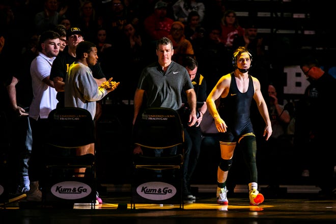 Iowa's Spencer Lee, right, walks out to the mat to wrestle at 125 pounds as head coach Tom Brands looks on during a Big Ten Conference men's wrestling dual against Nebraska, Friday, Jan. 20, 2023, at Carver-Hawkeye Arena in Iowa City, Iowa.