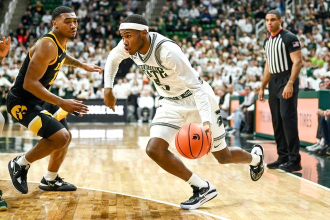 Michigan State's Tre Holloman, right, moves the ball against Iowa's Tony Perkins during the first half on Thursday, Jan. 26, 2023, at the Breslin Center in Lansing.

230126 Msu Iowa Bball 021a