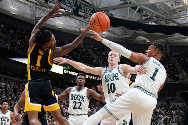 Iowa guard Ahron Ulis (1), Michigan State forward Joey Hauser (10) and guard Pierre Brooks (1) reach for the rebound during the first half of an NCAA college basketball game, Thursday, Jan. 26, 2023, in East Lansing, Mich. (AP Photo/Carlos Osorio)