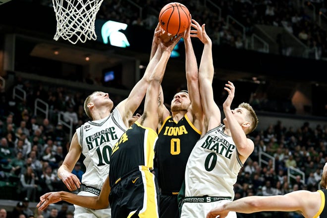 Michigan State's Joey Hauser, left, and Jaxon Kohler, right, go for a rebound with Iowa's Kris Murray, center left, and Filip Rebraca, center right, during the first half on Thursday, Jan. 26, 2023, at the Breslin Center in Lansing.

230126 Msu Iowa Bball 015a