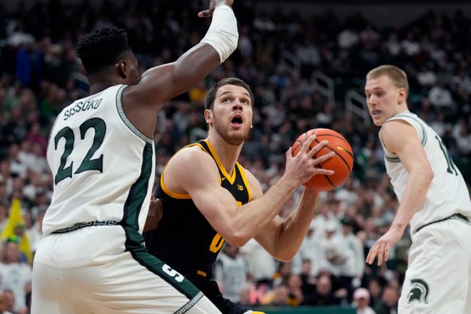 Iowa forward Filip Rebraca is defended by Michigan State center Mady Sissoko (22) during the first half of an NCAA college basketball game, Thursday, Jan. 26, 2023, in East Lansing, Mich. (AP Photo/Carlos Osorio)