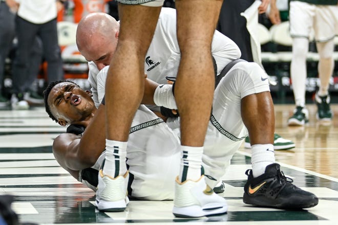 Michigan State's Tyson Walker is attended to after injuring his right leg during the second half in the game against Iowa on Thursday, Jan. 26, 2023, at the Breslin Center in Lansing. Walker returned to the game.