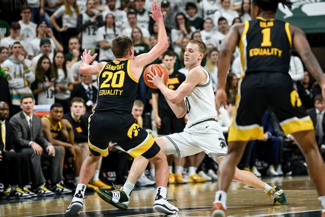 Michigan State's Joey Hauser, right, looks to pass as Iowa's Payton Sandfort defends during the second half on Thursday, Jan. 26, 2023, at the Breslin Center in Lansing.