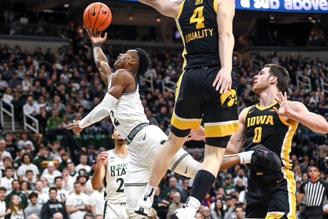 Michigan State's Tyson Walker, left, shoots a layup as Iowa's Filip Rebraca defends during the first half on Thursday, Jan. 26, 2023, at the Breslin Center in Lansing.
